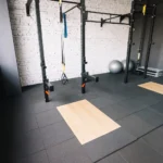 Worn rubber gym flooring showing signs of damage and wear that indicate it needs refinishing
