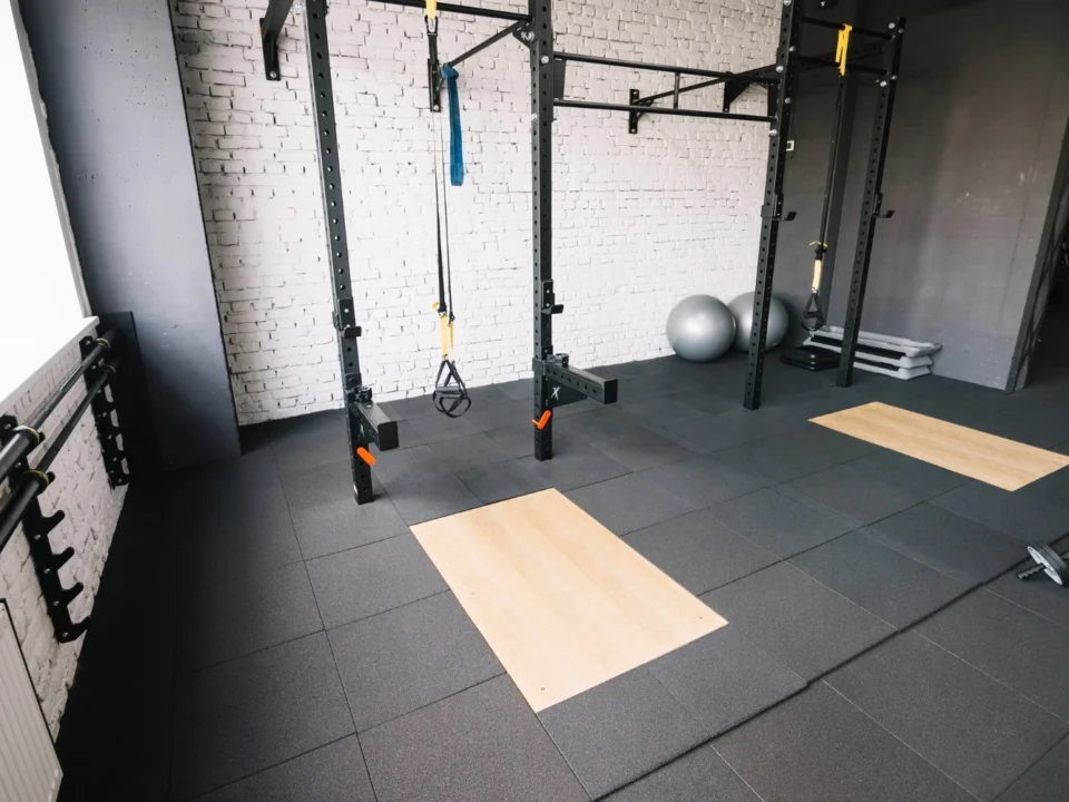 Worn rubber gym flooring showing signs of damage and wear that indicate it needs refinishing