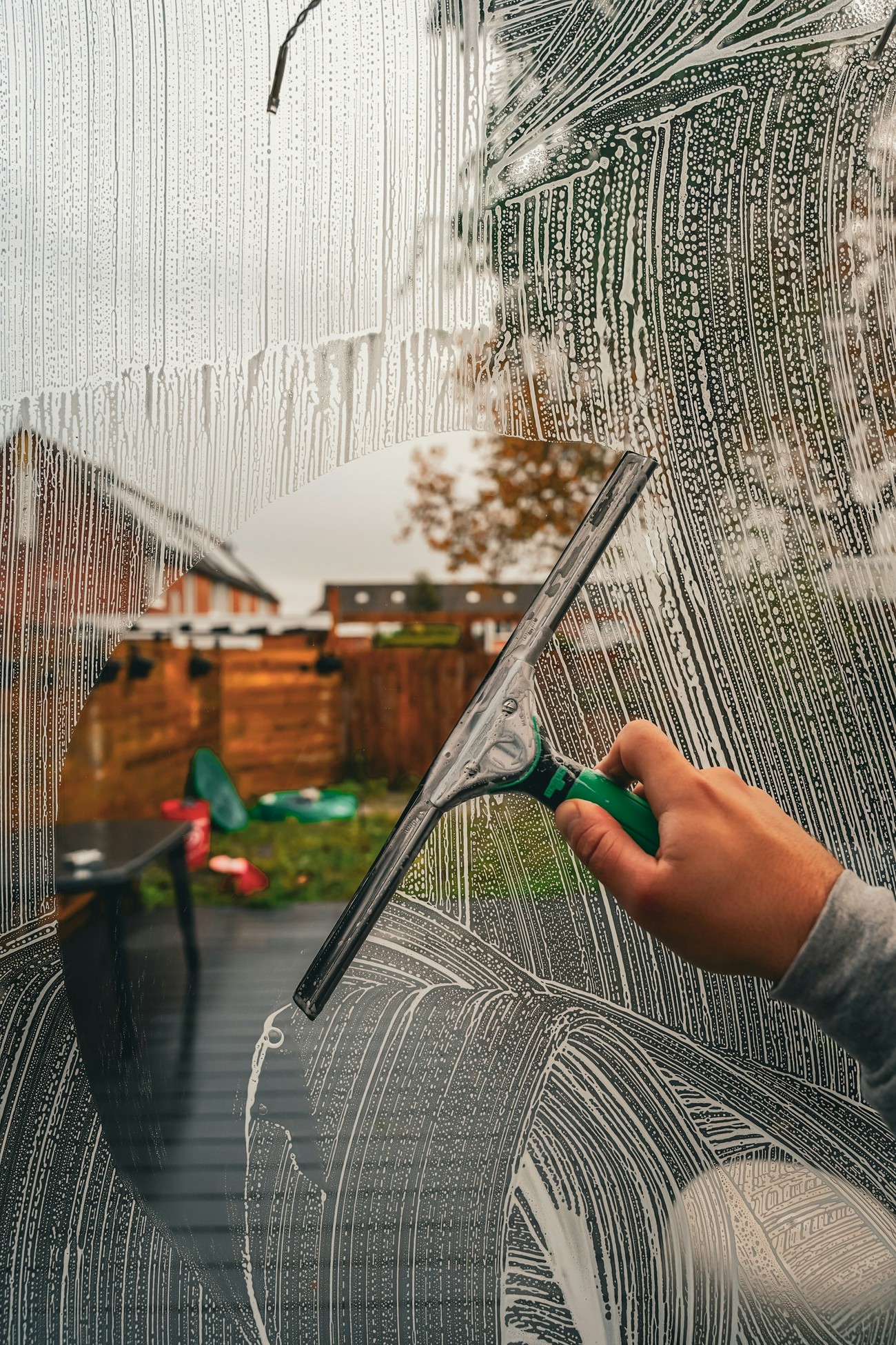 Professional technician cleaning residential windows, screens, and tracks at a Denver home