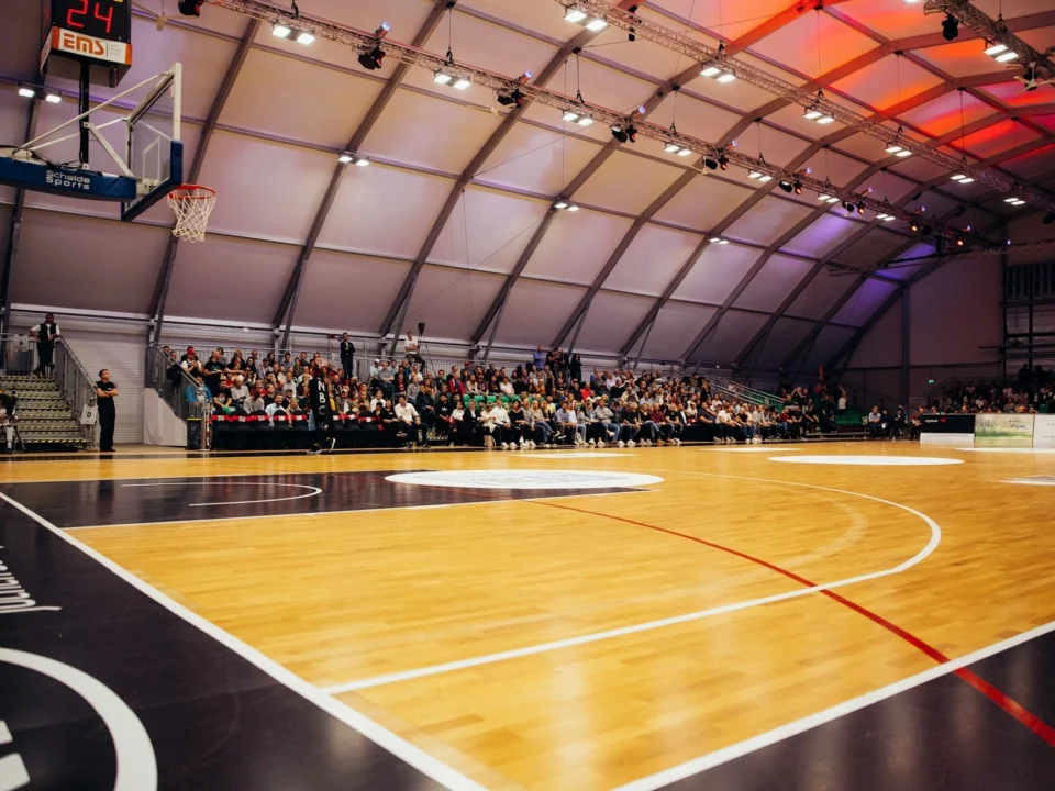 Professional hardwood basketball court flooring with polished maple surface for indoor sports facilities.
