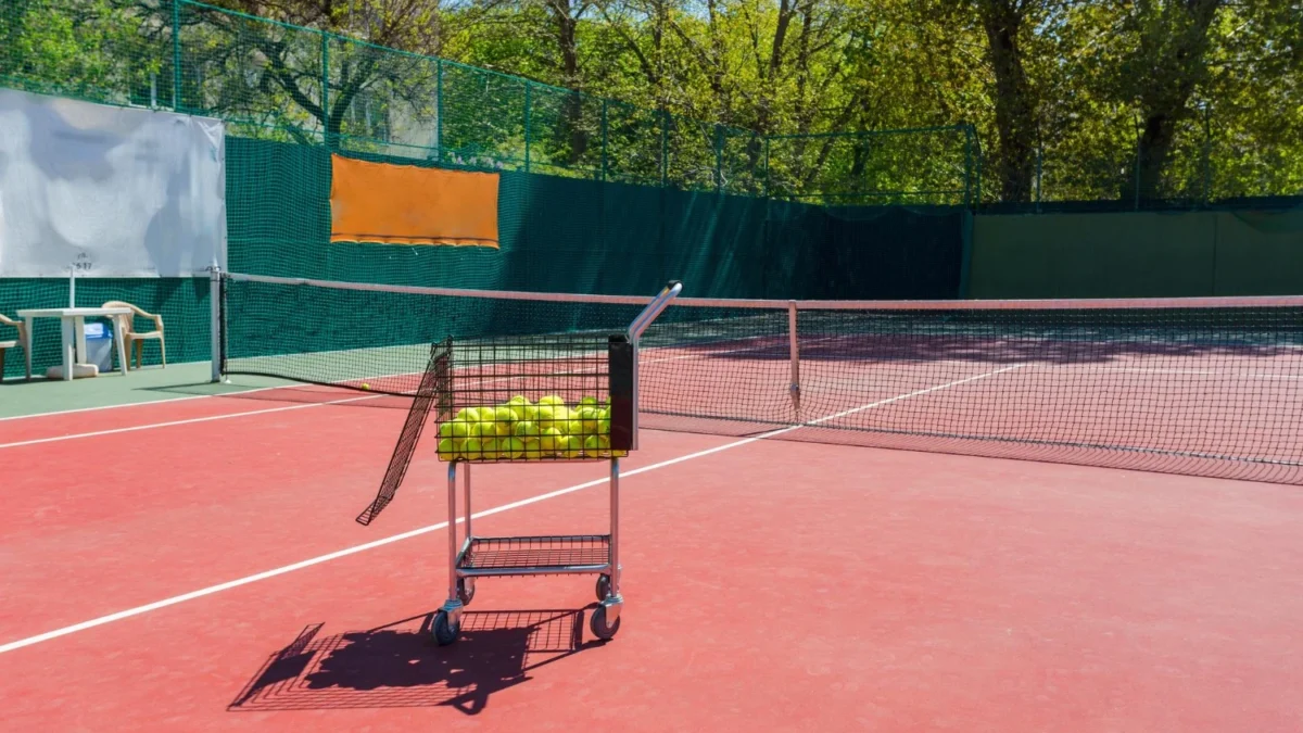 Outdoor tennis court showing surface cracks and faded court lines before professional tennis court resurfacing in Denver.