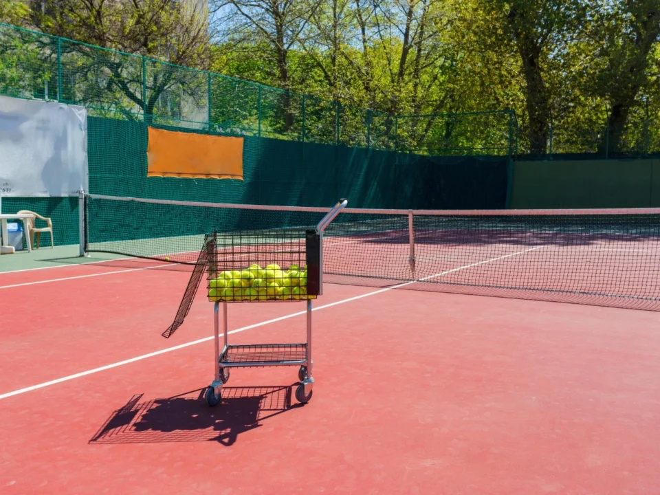Outdoor tennis court showing surface cracks and faded court lines before professional tennis court resurfacing in Denver.