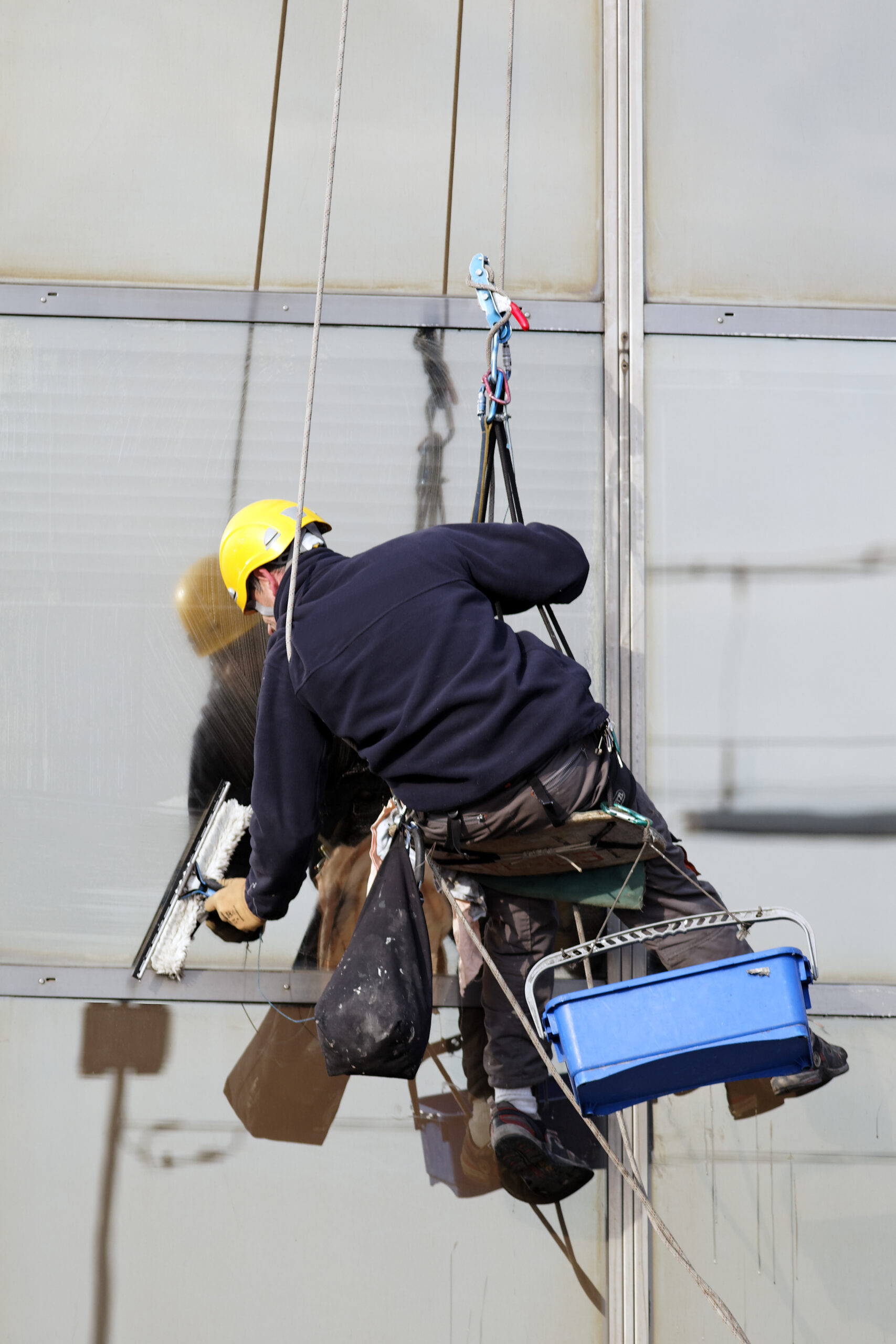 Professional technician cleaning residential windows, screens, and tracks at a Denver home